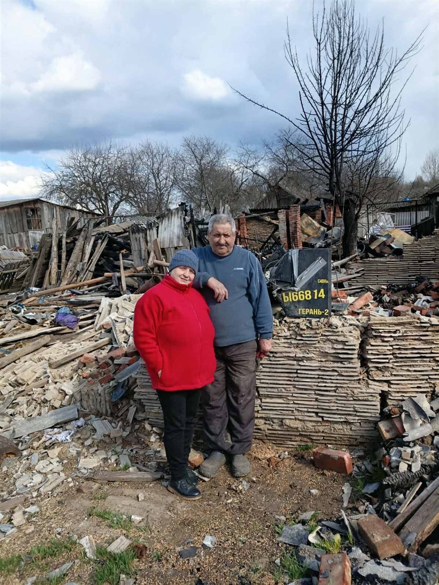 Подружжя біля розбитої ворогом оселі. В чужому одязі